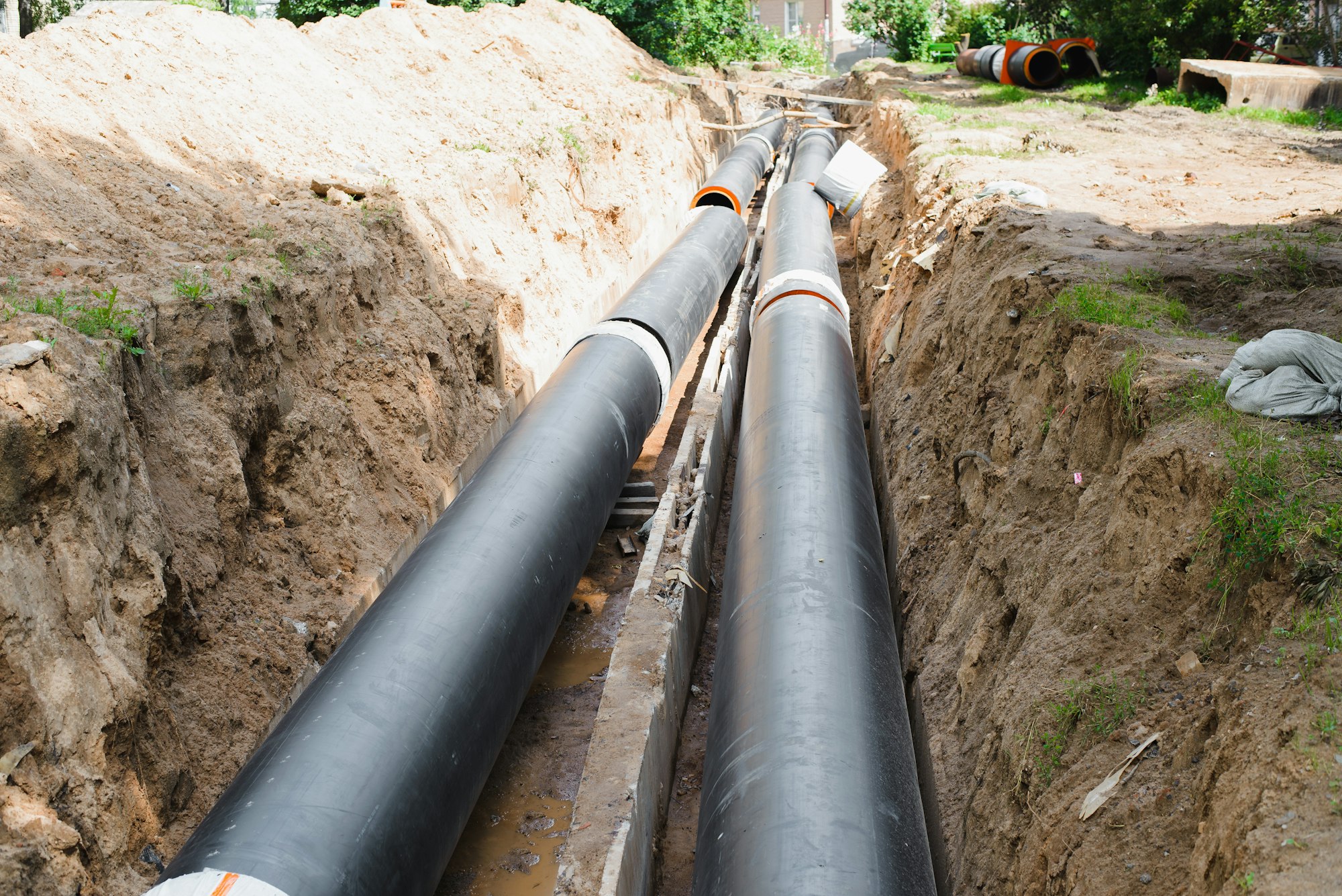 Plumbing repair. Installation of new industrial street water pipes in dug hole in two lines, outdoor